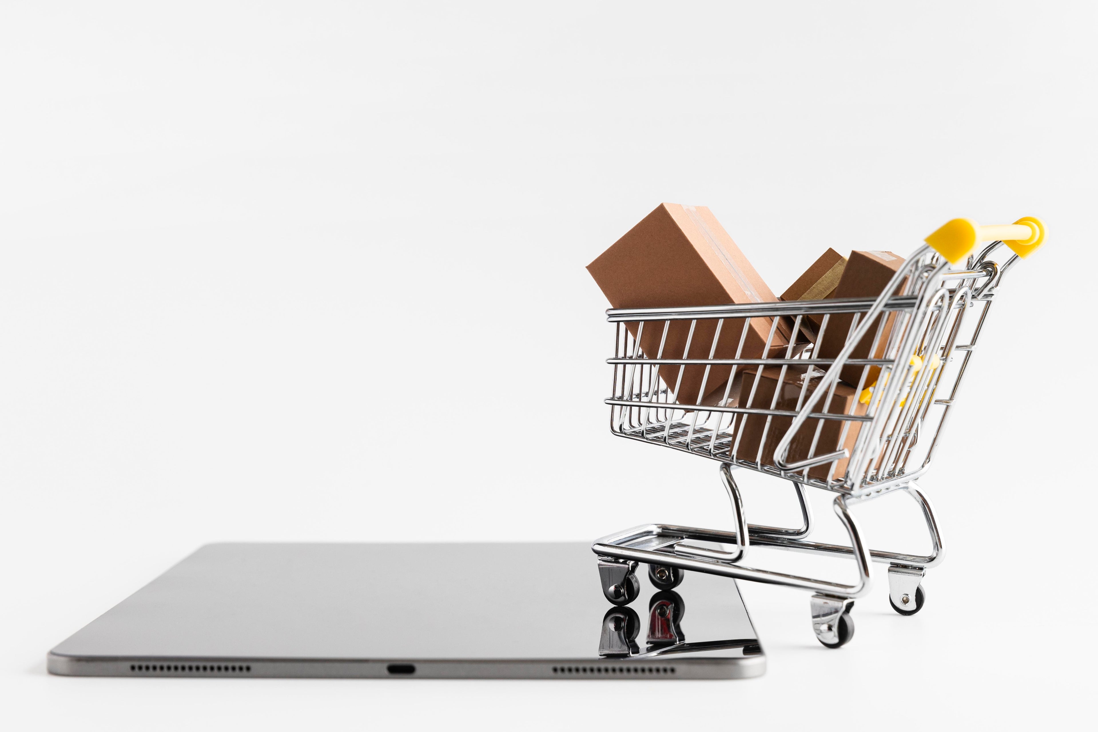 Shopping cart with boxes on a laptop computer, symbolizing online shopping. 